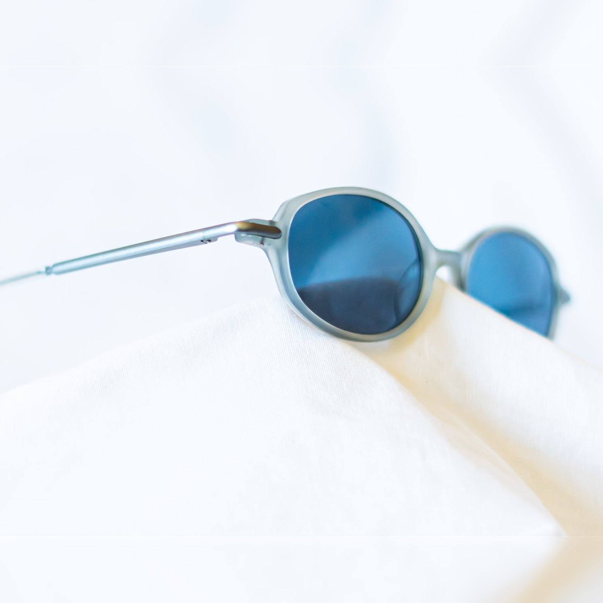 FROST Sunglasses - matte translucent grey oval frame with navy blue lenses